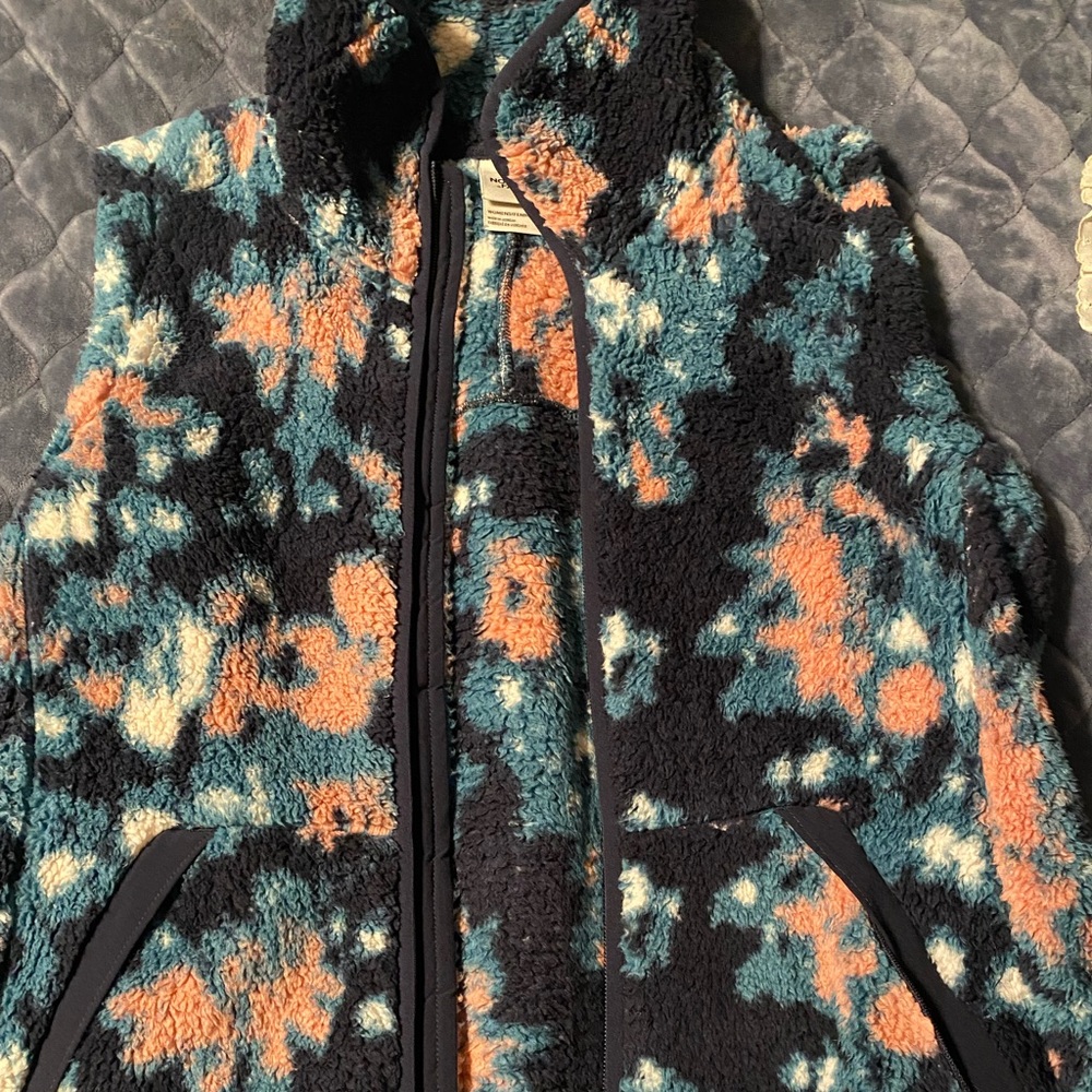 The NorthFace vest. Fleece/Sherpa material. Cozy, and warm.